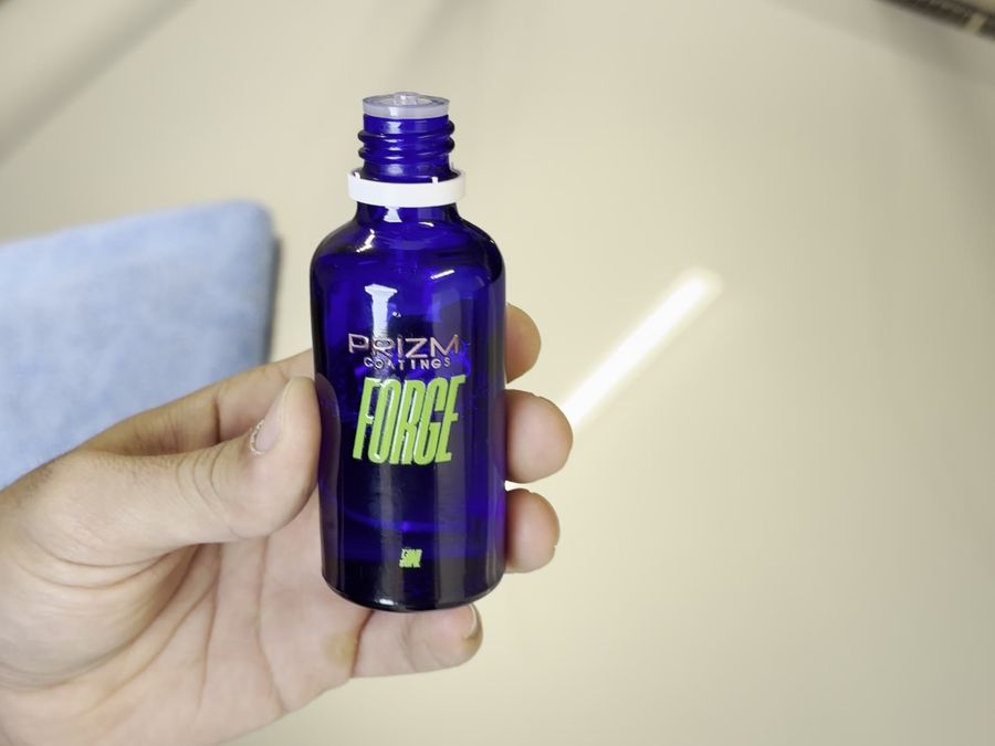 Prizm ceramic coating bottle and applicator on a freshly polished bonnet