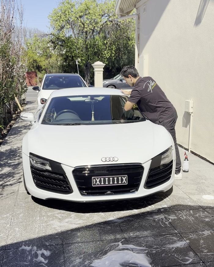 Hand drying an Audi R8 on the owner's driveway