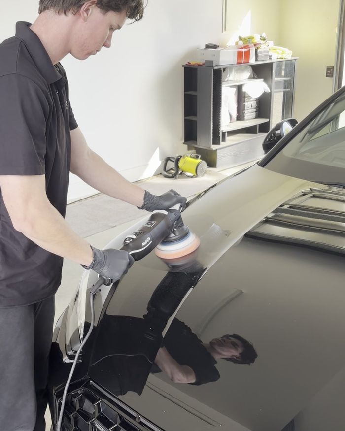Machine polishing a black Audi to remove swirl marks